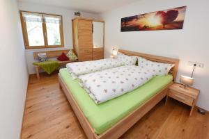 ein Schlafzimmer mit einem großen grünen Bett in einem Zimmer in der Unterkunft Ausblickhof Geiger in Egg