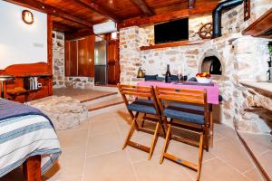 a kitchen with a table and a stone fireplace at Casa Campanella Holiday House in Rovinj