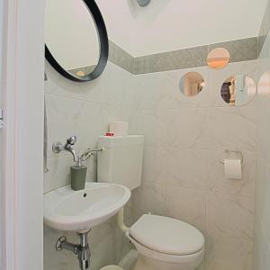 een badkamer met een toilet, een wastafel en een spiegel bij Apartment G37 in Zagreb +18 foto's