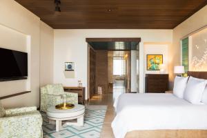a hotel room with a bed and a tv at Chileno Bay Resort & Residences, Auberge Resorts Collection in Cabo San Lucas