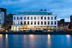 un bâtiment blanc à côté d'une étendue d'eau dans l'établissement Elite Stadshotellet Eskilstuna, à Eskilstuna