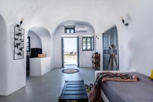 a living room with a bed and a hallway at Noelia Suites in Oia