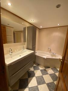 a bathroom with a tub and a sink and a mirror at Hotel Restaurant de Boekanier in Vrouwenpolder