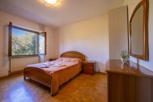 a bedroom with a bed and a table and a window at Villa Maria Paola in Nago-Torbole