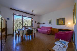 uma sala de estar com uma mesa e um sofá rosa em Villa Maria Paola em Nago-Torbole