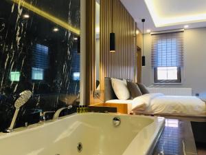 eine Badewanne in einem Zimmer mit einem Bett in der Unterkunft Kaya Life Resort in Uzungöl + 37 Fotos