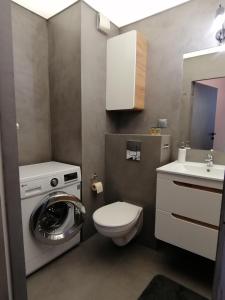 a small bathroom with a washing machine and a sink at Green Apartments Kraków in Kraków