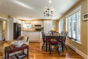 a kitchen and living room with a table and chairs at Lovely Lac-Brome 3 Bedroom Lakefront Cottage in Lac-Brome