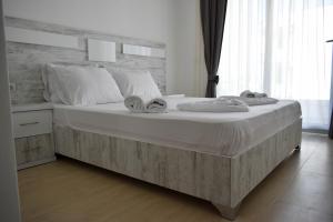 sypialnia z dużym łóżkiem z ręcznikami w obiekcie Lux Kalimera Apartments w Ulcinju