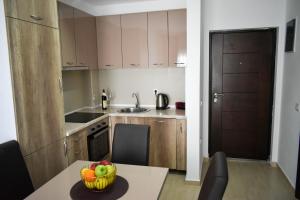 a kitchen with a bowl of fruit on a table at Lux Kalimera Apartments in Ulcinj