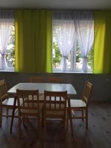 einen Tisch und Stühle in einem Zimmer mit Fenstern in der Unterkunft Anmar Kościuszki in Danzig