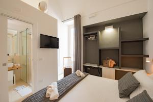 a bedroom with a large bed and a television at Suite1212 - Rattazzi in Monopoli