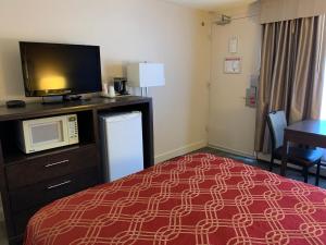 a bedroom with a bed and a desk at Econo Lodge Inn and Suites Lethbridge in Lethbridge