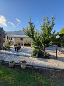 un patio avec des arbres et des plantes devant un bâtiment dans l'établissement Villa Soleanna Residence, à Vieste