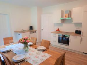 a kitchen with a wooden table with a vase of flowers at FeWo Forstvilla Beuron in Beuron