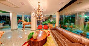 a living room with a leather couch and a chandelier at Amazon Plaza Hotel in Cuiabá