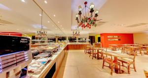 a restaurant with tables and chairs and a chandelier at Amazon Plaza Hotel in Cuiabá