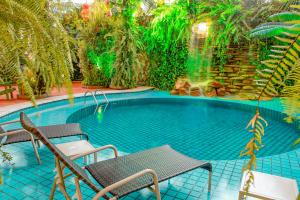 a large swimming pool with two chairs and a table at Amazon Plaza Hotel in Cuiabá