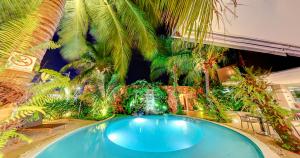 a large swimming pool in a yard with palm trees at Amazon Plaza Hotel in Cuiabá