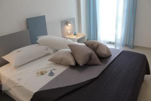 een slaapkamer met een bed met kussens en een raam bij GIOANTHONY in Porto Cesareo