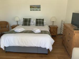 a bedroom with a bed with two towels on it at Portree Garden Room in Portree