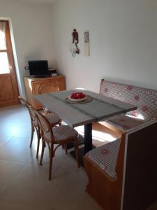 コンメッツァドゥーラにあるAppartamentoのダイニングルームテーブル(椅子付)、フルーツプレート