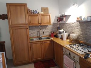 コンメッツァドゥーラにあるAppartamentoのキッチン(木製キャビネット、シンク付)