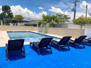um grupo de cadeiras sentadas ao lado de uma piscina em Villa Nova Condominio em La Plata