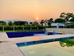 una piscina con puesta de sol en el fondo en Villa Nova Condominio, en La Plata