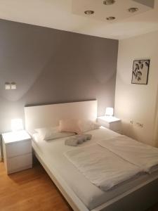 ein Schlafzimmer mit einem großen weißen Bett mit zwei Nachttischen in der Unterkunft Veliki Park in Šabac