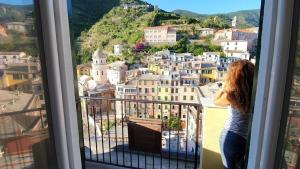 a woman looking out of a window at a city at Affittacamere Benedetta e Isabelle in Vernazza