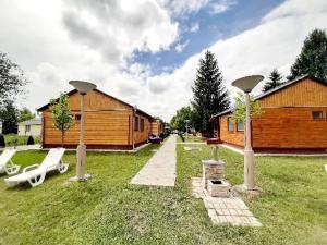 un patio con 2 sillas y una cabaña en Fortuna Apartmanházak, en Bogács