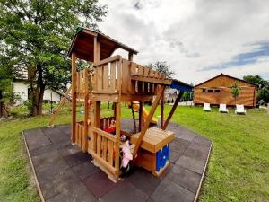 un patio de madera con una muñeca sentada en él en Fortuna Apartmanházak, en Bogács