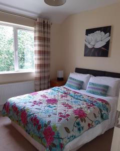 a bedroom with a bed with a colorful quilt on it at Foleys Ardmullen Manor Houses in Kenmare