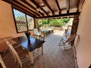 a dining room with a table and chairs on a patio at Casa Sole in Villasimius