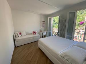 a white bedroom with a bed and a couch at Affittacamere Benedetta e Isabelle in Vernazza