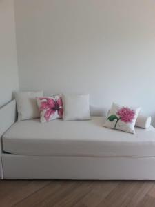 a white couch with three pillows on it at Affittacamere Benedetta e Isabelle in Vernazza