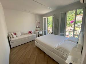 a white bedroom with a bed and a couch at Affittacamere Benedetta e Isabelle in Vernazza