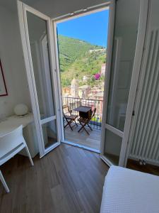 a room with a door open to a balcony with a table at Affittacamere Benedetta e Isabelle in Vernazza