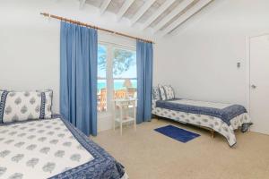 sypialnia z 2 łóżkami i oknem z widokiem w obiekcie Beachfront White Palm Villa- Tar Bay, Great Exuma w mieście Rokers Point Settlement