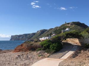 un conjunto de escaleras en una colina junto al océano en Ático de Jardines, en Denia