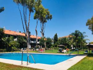 una piscina en un complejo con palmeras en PUERTO BANUS CRYSTAL Suite, en Marbella