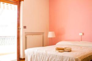 um quarto com uma cama com lençóis brancos e um candeeiro em Appartamento fronte mare a Villa Rosa (TE) em Alba Adriatica