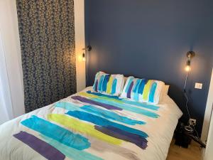 a bed with colorful sheets and pillows on it at La Baule Family in La Baule