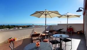 a patio with tables and umbrellas on a roof at Spiagge Iblee in Marina di Ragusa