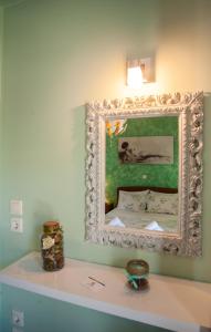 a mirror hanging on a wall above a white counter at Colourful apartments (Green Lagoon) in Argostoli