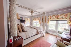 a bedroom with a canopy bed and a chair at Carriage Way Centennial House - Adult Only- Saint Augustine in St. Augustine