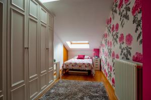 ein Schlafzimmer mit einem Bett und einer rosa Wand in der Unterkunft Duplex con encanto en Cimadevilla in Gijón