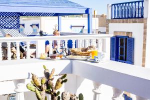 - une table avec de la nourriture sur le balcon dans l'établissement Hôtel Emeraude Essaouira, à Essaouira