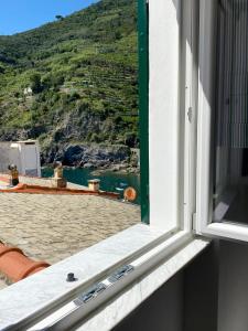 a window with a view of a beach and a mountain at Affittacamere Benedetta e Isabelle in Vernazza